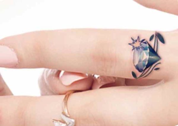 Beautiful tattoo with diamond on finger