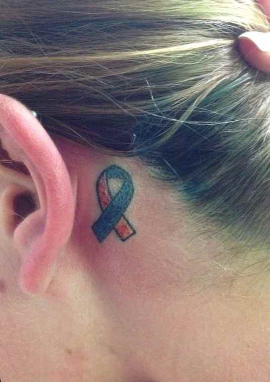 Cancer ribbon tattoo behind the ear