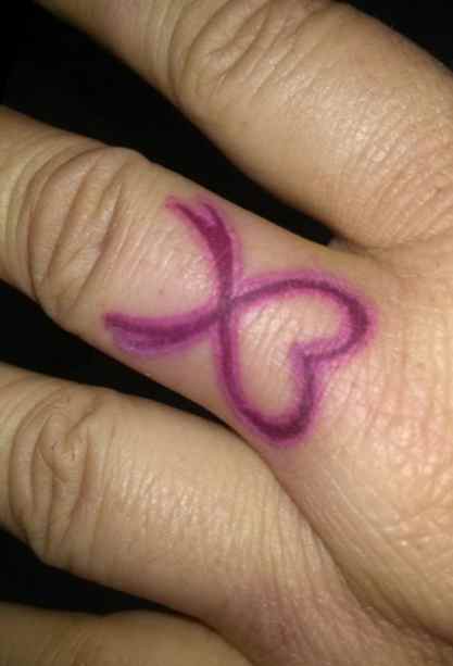 Cancer ribbon tattoo on fingers