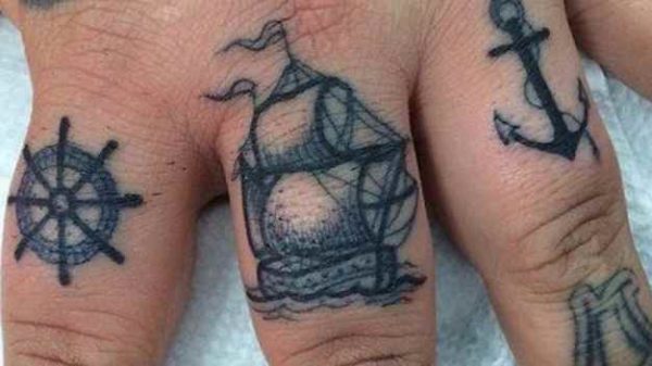 Ship wheel anchor finger tattoo