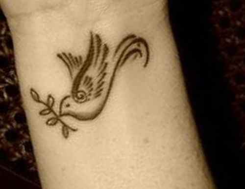 Flying dove wrist tattoo
