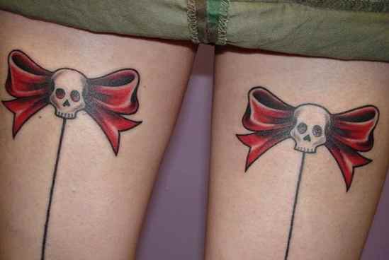 Ribbon tattoo on the back of thighs