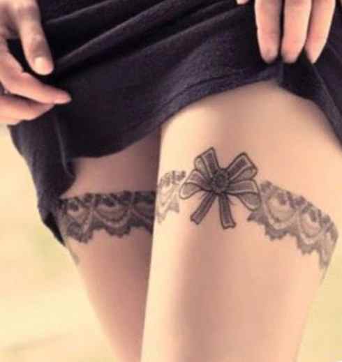 Ribbon tattoo on legs